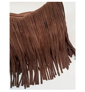 Detail of vintage caramel suede crossbody bag featuring long bohemian fringe tassels