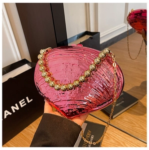 Vue détaillée de la pochette coquillage fuchsia métallisé avec poignée en perles dorées