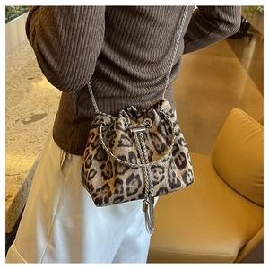 Detail of leopard print bucket bag featuring silver ring handle and metal tassels