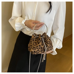 Leopard print bucket bag with silver metal ring handle and chain strap on a model