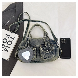 Detail of vintage denim crossbody bag with cargo pockets and a heart-shaped mirror charm