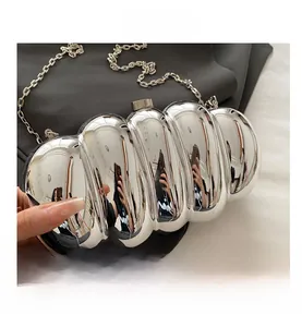 Macro shot of silver metallic ripple texture and chain strap on stylish evening clutch bag