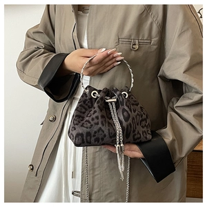 Close-up of leopard print bucket bag with silver metal handle and drawstring chain