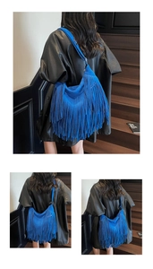 Detail of royal blue suede hobo bag featuring long stylish fringe and spacious interior