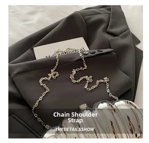 Close-up of a silver acrylic evening clutch bag with wavy texture and fine metal chain