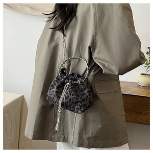 Detail of leopard print bucket bag with metal handle, chain strap and silver tassels