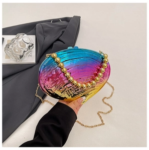 Détail de la pochette de soirée irisée en forme de coquillage avec poignée à perles dorées