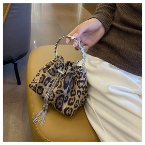 Detail of leopard print bucket bag with silver chain handle and metallic tassels