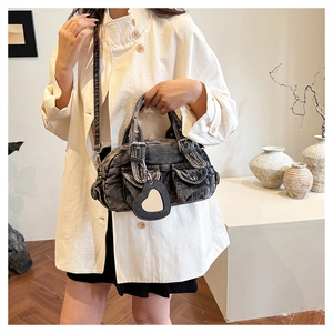 Close-up of vintage grey denim handbag with multi-pockets and heart mirror charm accessory