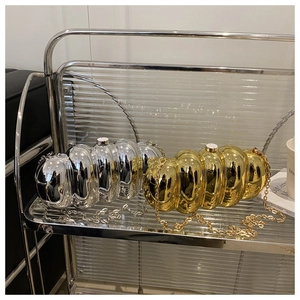 Close-up of metallic gold and silver acrylic evening bags with unique pleated texture
