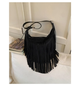 Detailed view of black matte leather bag featuring long fringe and vintage tassel design
