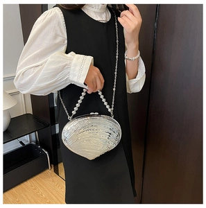 Détail du sac de soirée argenté en forme de coquillage avec poignée en perles et chaîne
