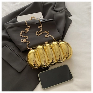 Macro shot of gold acrylic evening clutch with wavy texture on a grey suit jacket