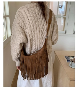 Lifestyle shot showing the detail of a brown suede bohemian crossbody bag with long tassels
