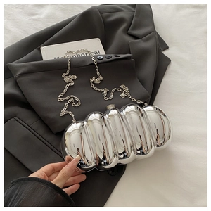 Detailed view of silver metallic ribbed evening clutch bag with glossy finish and chain