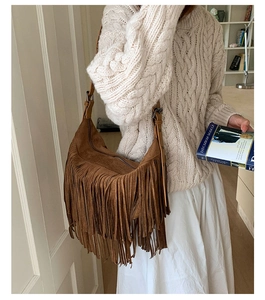 Detail of bohemian brown suede hobo bag with long fringe and adjustable leather strap