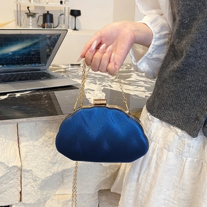 Navy blue shell-shaped evening bag with wavy metallic texture and gold chain strap
