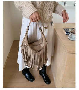 Detail of tan faux suede tassel shoulder bag with textured fringe and crescent shape