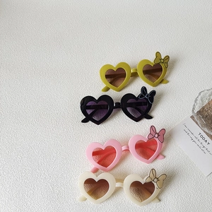 Kids heart shaped sunglasses with bow detail in yellow, black, pink, and cream colors