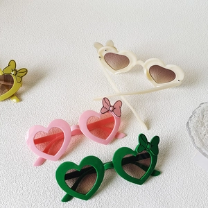Group view of heart-shaped kids sunglasses with bow accent in four different colors