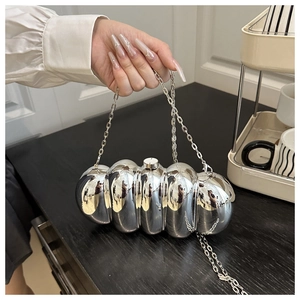 Close-up of a silver caterpillar-shaped evening clutch bag with metallic vertical texture