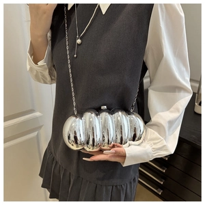 Detail of mirrored silver cloud-shaped acrylic clutch bag with metal chain strap