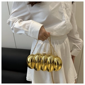 Close-up of a glossy gold caterpillar acrylic evening bag with a metallic chain strap