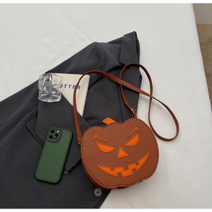 Creative pumpkin crossbody bag placed on a grey blazer with lifestyle accessories