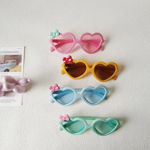 Lunettes de soleil enfant en forme de cœur avec nœuds en rose, jaune, bleu et vert