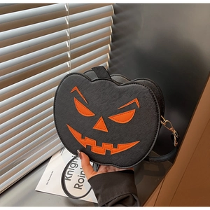 Detail of Halloween pumpkin round crossbody bag with orange Jack-o'-lantern face and gold hardware