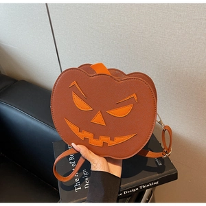 Detail of pumpkin-shaped crossbody bag featuring stitched evil smile and PU leather texture