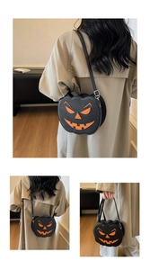 Détail d'un sac bandoulière citrouille noir avec visage de Jack-o'-lantern orange