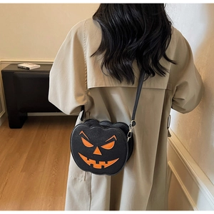 Detail of Jack-o'-lantern pumpkin crossbody bag worn with a beige trench coat