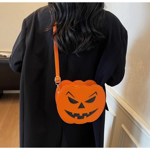 Detail of Jack-o'-lantern pumpkin crossbody bag with black facial details and PU strap