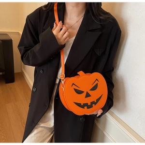 Close-up of Halloween pumpkin crossbody bag with black Jack-o'-lantern face on model