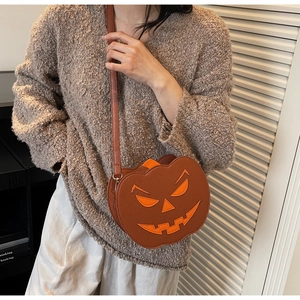 Detail of pumpkin crossbody bag with orange facial appliqué and adjustable strap
