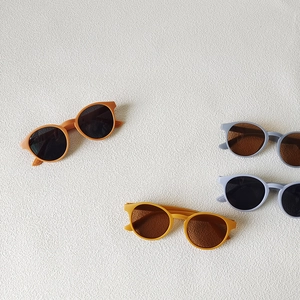 Minimalist round children's sunglasses in orange, yellow, and blue with dark lenses