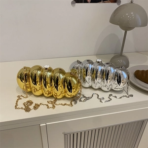 Glossy acrylic caterpillar clutch bag in gold and silver with metal chains