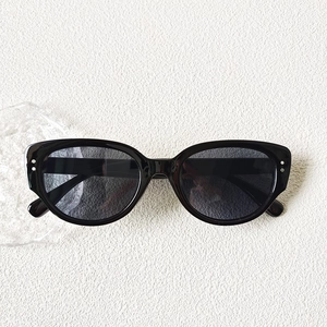Gros plan sur les lunettes de soleil œil-de-chat noires avec rivets et verres gris