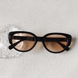 Vue détaillée de dessus des lunettes de soleil Y2K œil-de-chat noires à verres ambrés
