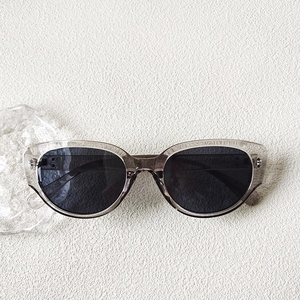 Vue détaillée de lunettes de soleil œil-de-chat avec monture grise et rivets en métal