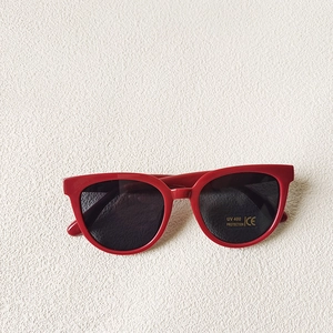 Détail de lunettes de soleil rondes rouges pour enfant avec étiquette de protection UV400