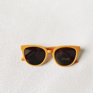 Détail de lunettes de soleil jaunes rondes avec verres noirs et certification UV400 CE