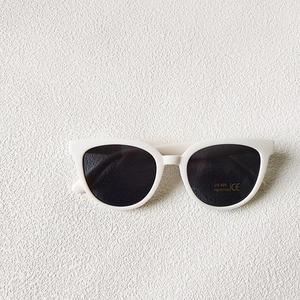 Détail de lunettes de soleil rondes blanches montrant la protection UV400 et le marquage CE