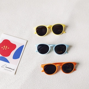 Tre paia di occhiali da sole alla moda per bambini nei colori giallo, azzurro e arancione