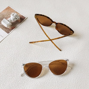 Detailed view of tortoiseshell and transparent cat eye sunglasses for children in brown lenses
