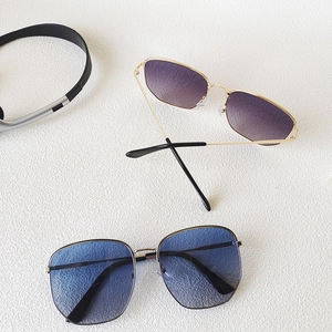 Flat lay of oversized square sunglasses with purple and blue gradient lenses