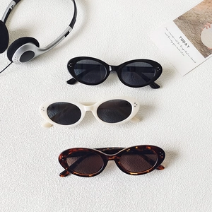 Retro oval sunglasses in black, cream, and tortoiseshell colors with UV protection
