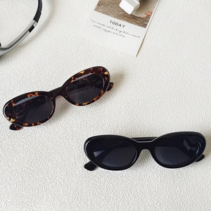 Occhiali da sole ovali vintage cat-eye in stile leopardato e nero con estetica minimalista