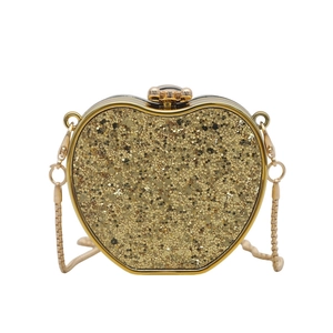 Detail of a heart-shaped evening bag with gold sequins, floral clasp and metal chain